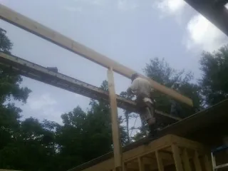Carpenter setting a ridge beam over a new addition frame — Ice Dam Removal by Roofing Brothers in Rowlesburg
