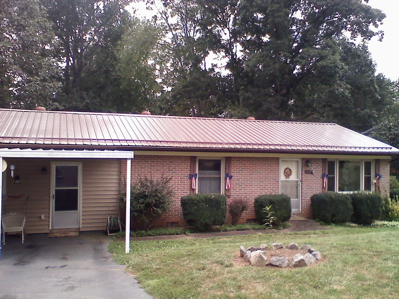 Bronze metal roof and carport on a brick ranch home — Roof Repair work by our crew in Rowlesburg
